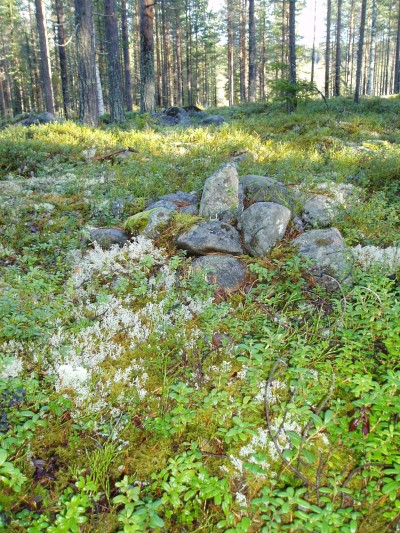 Råsten med en rest toppig sten med stenar runt.