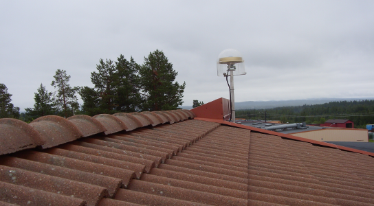  The GNSS antenna at the Class B station in Storuman can be seen above the roof of the building where it is installed.